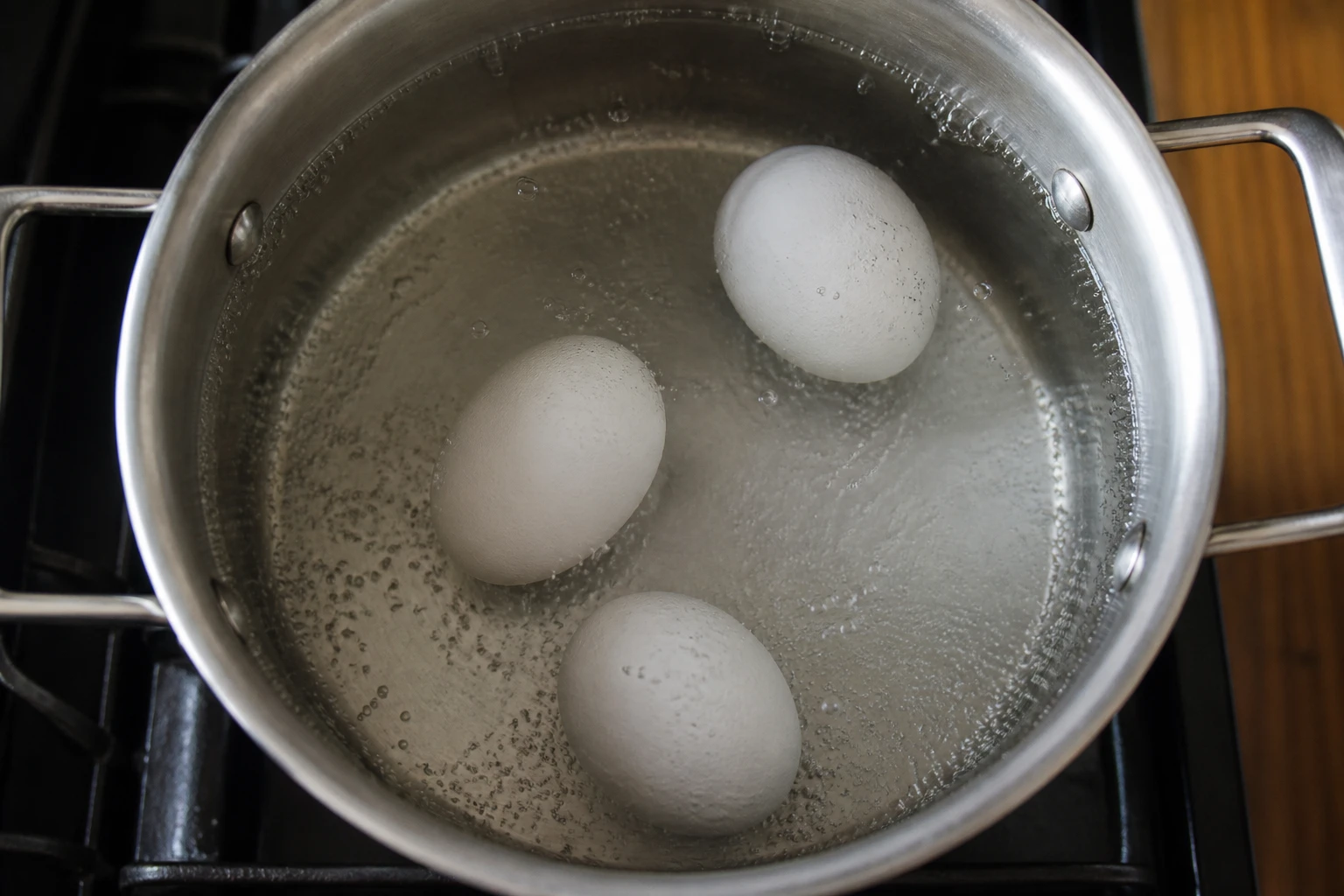 Œufs à différents stades de flottaison dans une casserole d'eau frémissante